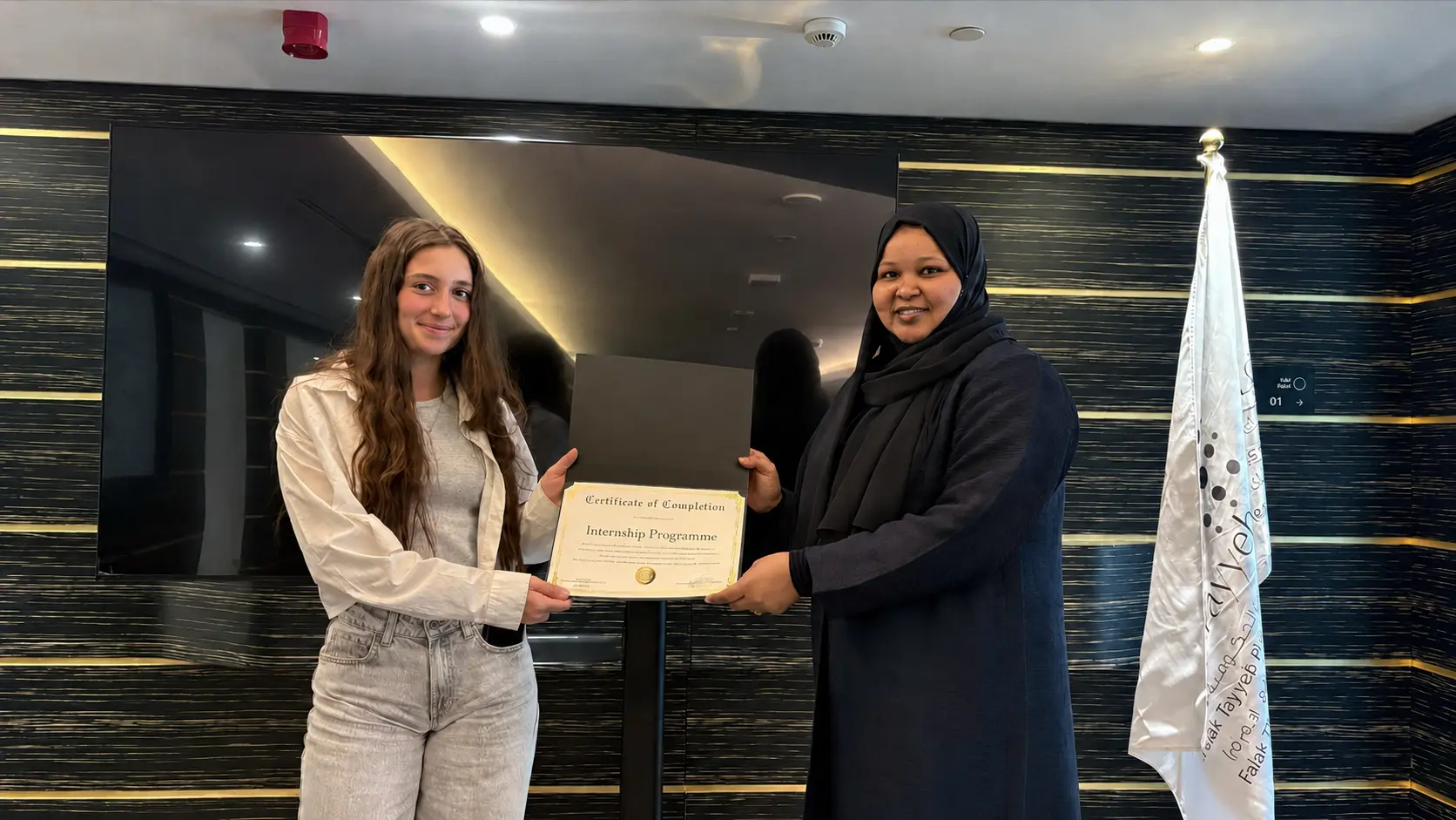 A student receiving a certificate after completing a cross-department internship at FTP
